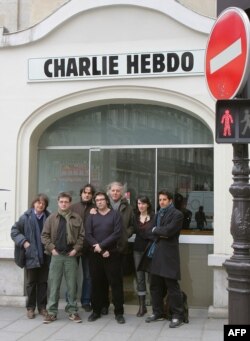 Membri redacției revistei satirice Charlie Hebdo, pozînd în fața sediului lor