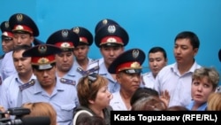 Police officers block the prison gate as prisoners' relatives gather to see their loved ones in Almaty on July 30.