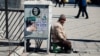 چسباندن پوستر در معابر عمومی شیوه‌ای رایج در تبلیغات انتخاباتی است، همدان، ۲۵ بهمن ۹۸
