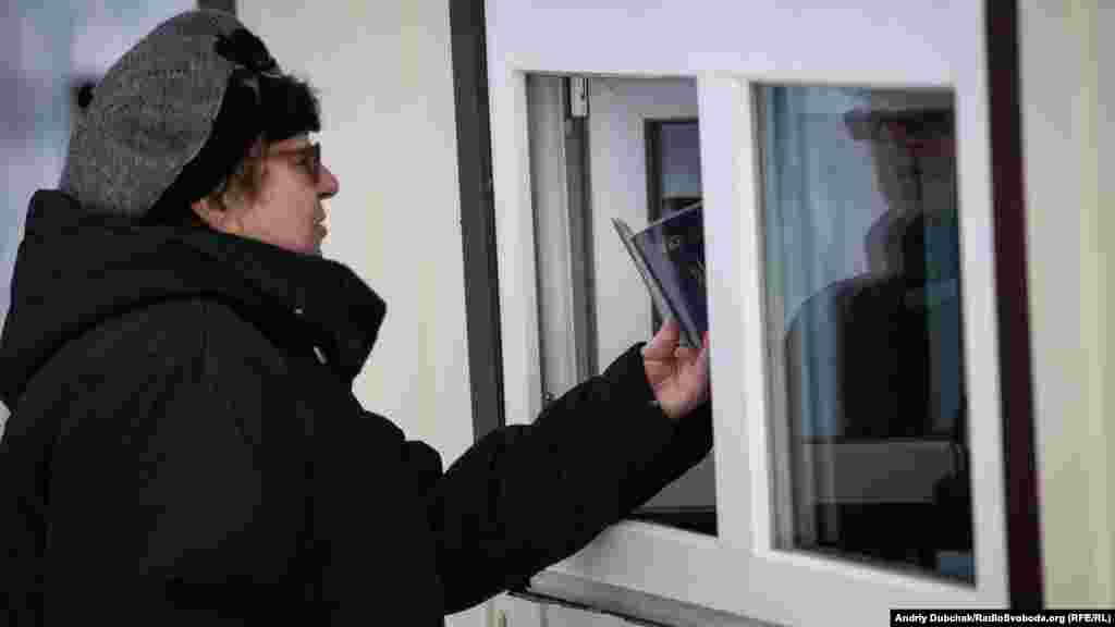 A woman having her passport checked by a Ukrainian official.