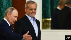 Russia - Russian President Vladimir Putin gestures next to Iranian President Masoud Pezeshkian as they attend a signing ceremony at the Kremlin in Moscow, January 17, 2025. 