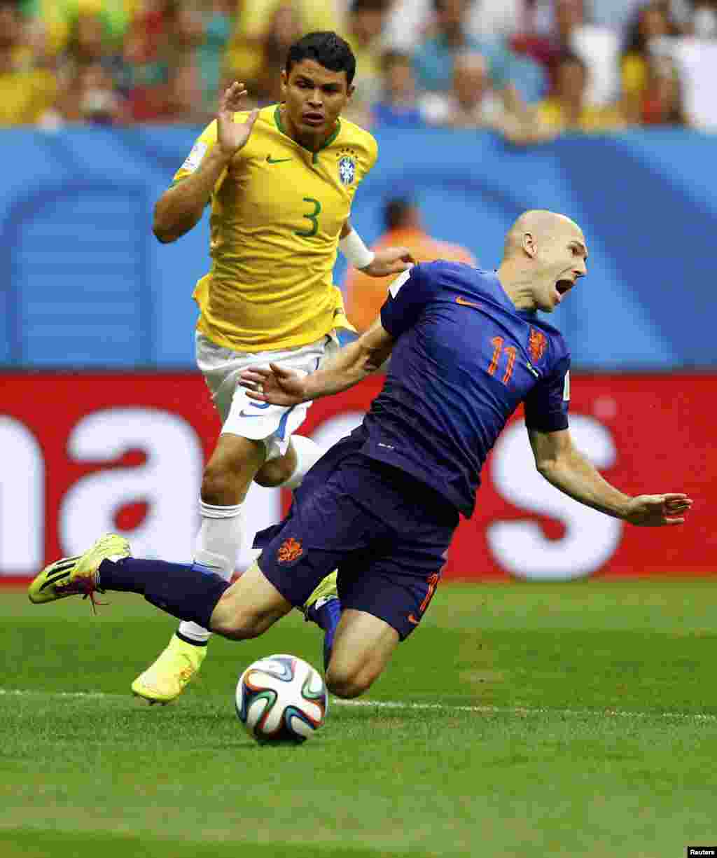 Brazil. 12Jul.Brazil's Thiago Silva (L) fouls Arjen Robben of the Netherlands to concede a penalty during their 2014 World Cup third-place playoff at the Brasilia national stadium in Brasilia