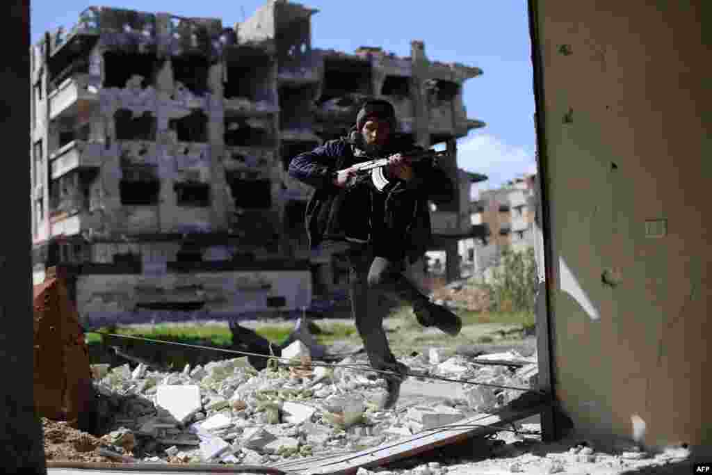 A fighter belonging to Jaish al-Islam (Army of Islam) runs to take cover near the front line in the neighborhood of Jobar, on the eastern outskirts of the capital, Damascus. (AFP/Amer Almohibany)