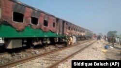 Pakistani officials examine a train damaged by a deadly fire in Punjab Province on October 31. 