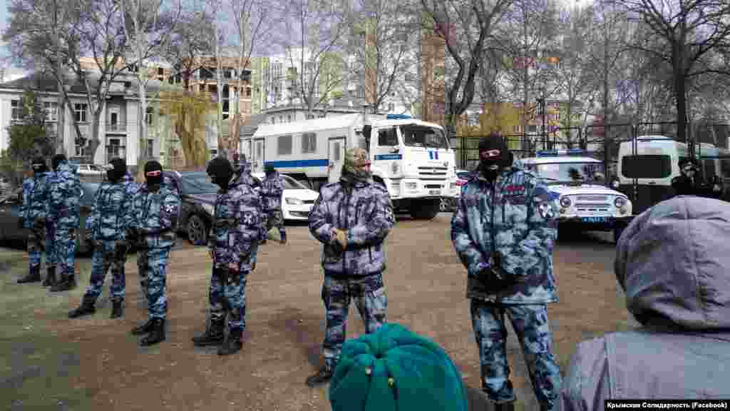 Rusiye kontrolindeki Aqmescitniñ Kiyev rayon mahkemesiniñ binası ögünde Rusiye uquq qoruyıcıları
