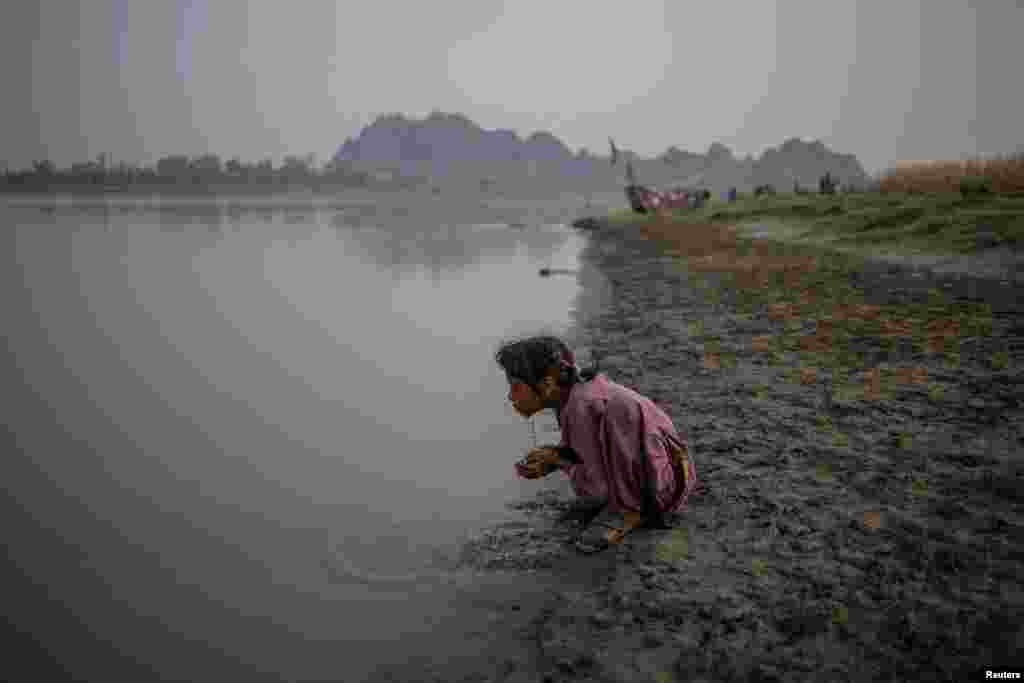 A Pakistani girl washes her face on the banks of the Chenab River in Chiniot in Punjab Province.