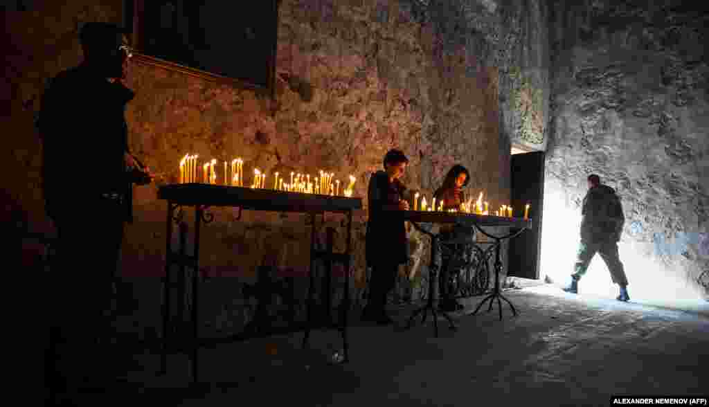 Candles burn inside the monastery on November 12 as a mix of soldiers and civilians arrive to pay their respects. 