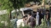 People gather at the scene after a bus carrying pilgrims of the Sikh minority, which was hit by a train, in the district of Sheikhupura in the eastern Punjab Province.