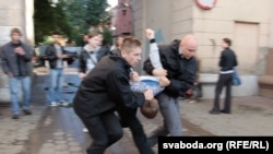 Plainclothes police officers arrest a protester in Minsk on July 3.