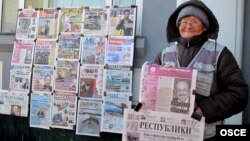 Астанада газет сатып тұрған әйел. (Көрнекі сурет)