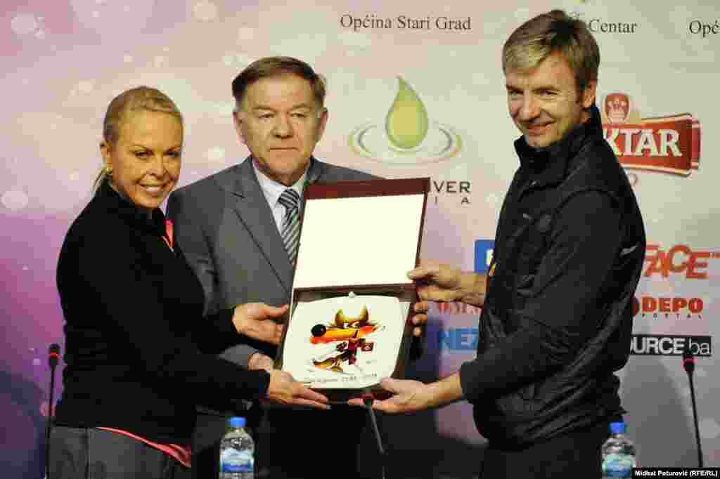Jayne Torvill, Sarajevo Mayor Ivo Komsic, and Christopher Dean holding a drawing of Vucko, the official mascot of the 1984 Winter Olympics.