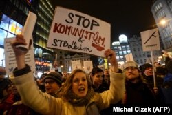 Участница протеста против премьер-министра Чехии Андрея Бабиша. На ее плакате написано "Стоп – коммунистам и агентам госбезопасности". Прага, 5 марта 2018 года