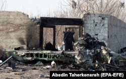 Іранський поліцейський стоїть поруч із уламками літака після катастрофи українського Boeing 737. 8 січня 2020 року, Шахріарі, Іран