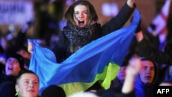 Участница антиправительственной демонстрации с украинским флагом выкрикивает лозунги на Майдане Незалежности в Киеве. 2 декабря 2013 года. 