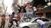 Актывісты Нацыяналістычнай партыі Банглядэшу разьбіваюць паліцыйнае аўта падчас беспарадкаў у сталіцы краіны Дацы, 14 лістапада