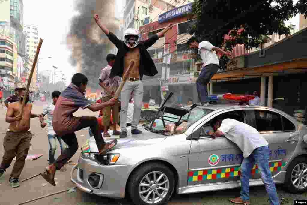 Bangladeşiň milletçi partiýasynyň aktiwistleri Dhakadaky çaknyşyklar mahalynda polisiýanyň maşynyny döwýär. (Reuters/Stringer)