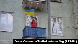 Женщина приветствует участников украинского марша