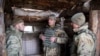 Дмитрий Делятицкий (в центре) слушает доклад матроса морской пехоты о ситуации на передовой