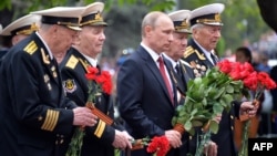 Russian President Vladimir Putin (center) and World War II veterans lay flowers at a war memorial in the Crimean port of Sevastopol on May 9.