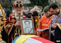 Orthodox priests stand next to a coffin containing the body of opposition journalist Heorhiy Gongadze, who was killed in 2000 but not laid to rest until earlier this year.