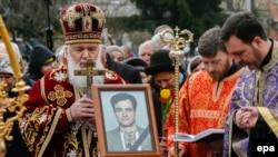 Orthodox priests stand next to a coffin containing the body of investigative journalist Heorhiy Gongadze, who was killed in 2000, during a funeral ceremony in Kyiv on March 22. 