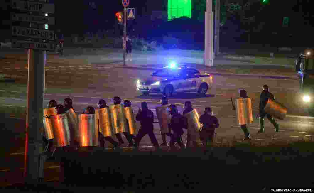 Riot police advance along a street in Minsk in the early hours of August 12.