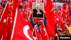 A supporter of Turkish President Tayyip Erdogan holds up a picture during a rally in Cologne last year. 