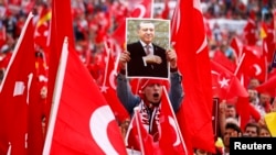 Germany, Cologne, a supporter of Turkish President Tayyip Erdogan holds up a picture during a pro-government protest 311ju1l2016