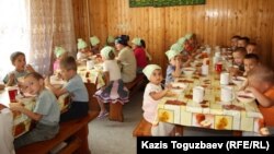 Дети младшей группы приюта отца Софрония обедают. Поселок имени Туймебаева Илийского района Алматинской области. 24 июля 2013 года. 