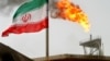 FILE PHOTO: A gas flare on an oil production platform in the Soroush oil fields is seen alongside an Iranian flag in the Persian Gulf.