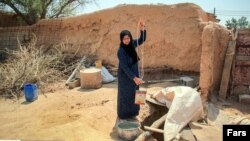 Woman drawing water from a well in Gheizanieh, Khuzestan. Undated photo. 