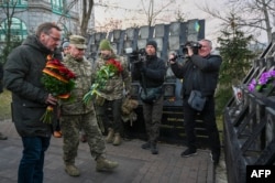 Министр обороны ФРГ Борис Писториус (слева) вместе с украинскими военными возлагает цветы к мемориалу в Киеве, 21 ноября 2023 года