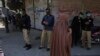 FILE: Police officers stand guard to try to enforce a nation-wide lockdown, at a market in Peshawar in April.