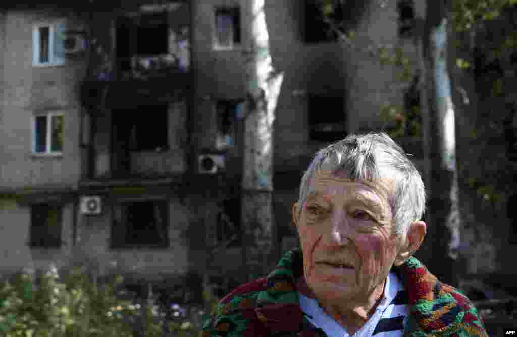 A Ukrainian man who left his burned flat stands in front of a building destroyed by shelling on September 17&nbsp;near&nbsp;the international airport in Donetsk. (AFP/Philippe Desmazes) 