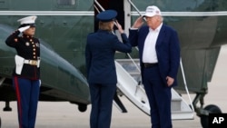US President Donald Trump salutes an Air Force colonel before boarding the Marine One helicopter on May 25.