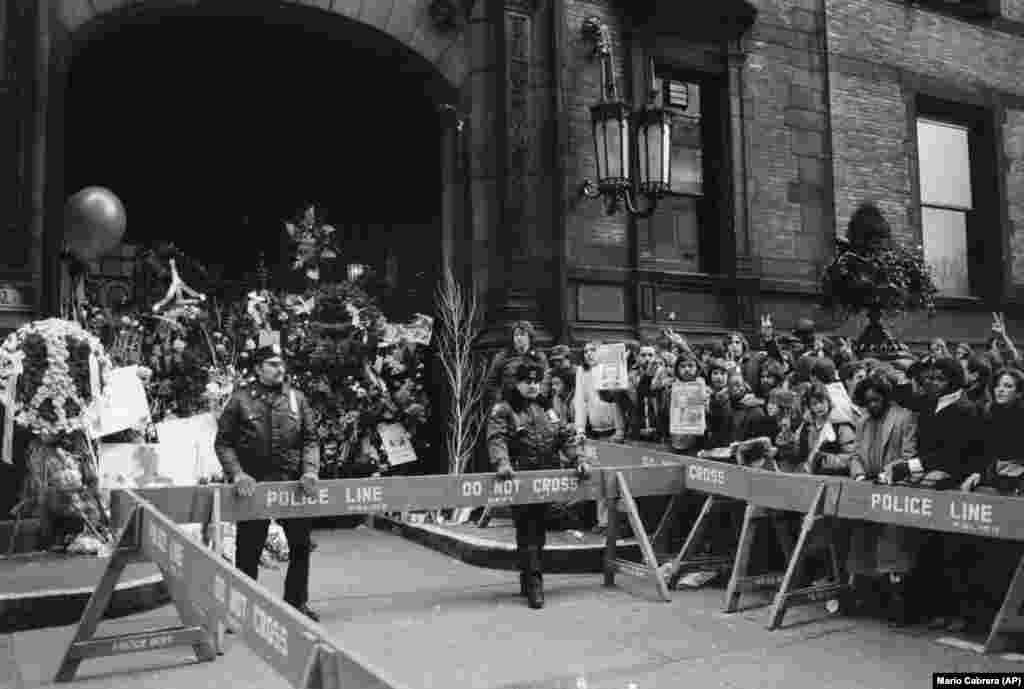 Толпа фанатов у многоквартирного дома &laquo;Дакота&raquo; в Нью-Йорке, где жил и был убит Леннон. Полиция охраняет место убийства,&nbsp;9 декабря 1980 года