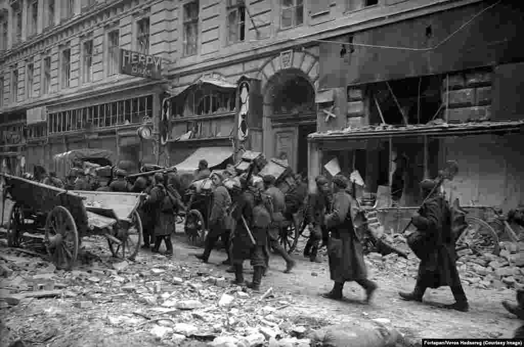 A Vörös Hadsereg katonái Budapesten. Túlélők visszaemlékezései szerint amikor az előrenyomuló szovjet csapatok megérkeztek, sok katona vizet és cigarettát adott a civileknek, mások azonban raboltak és fosztogattak