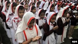 Pakistani schoolchildren in Karachi pray for pupils who were killed in a Taliban attack on an army-run school in Peshawar.