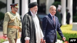 Iranian President Ebrahim Raisi (center) walks with Pakistani Prime Minister Shehbaz Sharif (right) to inspect a guard of honor in Islamabad on April 22.