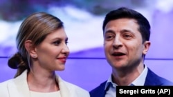 Volodymyr Zelenskiy, and his wife, Olena, greet supporters at his headquarters after the presidential election in Kyiv on April 21.