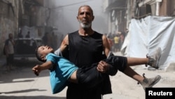 პალესტინელ კაცს დაჭრილი ბავშვ მიჰყავს, ისრაელის მიერ განხორციელებული საჰაერო დარტყმის შემდეგ. ღაზა, 2025 წლის 7 სექტემბერი.