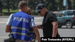 Сотрудник органов не в форме проверяет журналистов в Алматы
