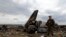 An armed pro-Russian separatist stands guard at the site of the crash of the Il-76 Ukrainian army transport plane in Luhansk on June 14. 