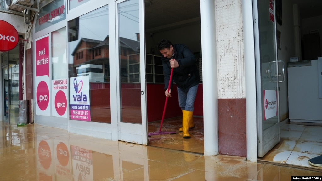 Një qytetar pastron ujin që ka hyrë në një dyqan në Malishevë.