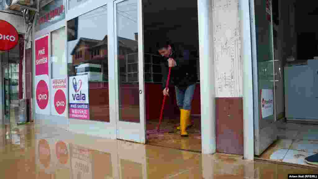 Građanin izbacuje vodu koja je ušla u prodavnicu u Mališevu.