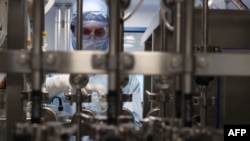 Dolgozó a Pfizer koronavírus-vakcinát gyártó üzemében