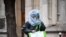 Un bărbat care se protejează cu o pungă de plastic merge pe o stradă din Paris, 21 martie