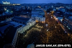 ადამიანები მობილური ტელეფონების ფანრებს ანთებენ, როდესაც მონაწილეობენ აქციაში სახელწოდებით „დავდგეთ ღირსებისთვის სლოვაკეთში“, ბრატისლავა, სლოვაკეთი, 2018 წლის 16 მარტი.