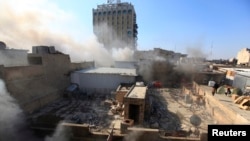 Smoke rises from the site of a bomb attack near Khullani Square in Baghdad on February 5.