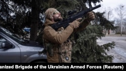 A Ukrainian soldier monitors the sky for Russian drones during an evacuation of an injured service member in the Donetsk region in February. 